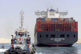 Boats, including a container ship, cross the new waterway of the Suez canal on July 25, 2015, in the Egyptian port city of Ismailia, east of Cairo. Egypt began the first trial run of its 'new Suez canal,' officials and state media said, ahead of the formal inauguration of the new shipping route on August 6. Dubbed the Suez Canal Axis, the new 72-kilometre (45 mile) project is aimed at speeding up traffic along the existing waterway by reducing the waiting period of vessels, as well as boosting revenues for Egypt. AFP PHOTO / STR