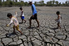 A father with his children walk over the cracked soil of a 1.5 hectare dried up fishery at the Novaleta town in Cavite province, south of Manila May 26, 2015. President Benigno Aquino III approved the proposal of the National Food Authority (NFA) to import further 250,000 tonnes of rice as the drought-inducing El Nino weather phenomenon continue to affect farmlands in the provinces resulting to more damaged crops. REUTERS/Romeo Ranoco