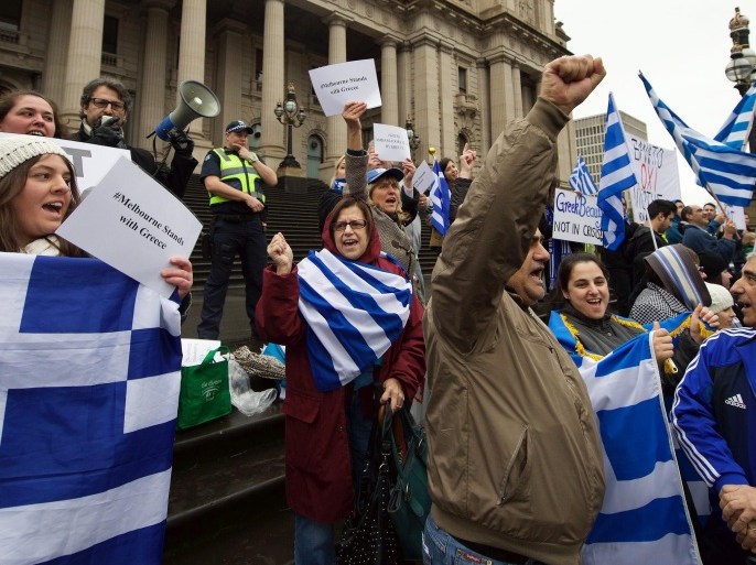 Protestors wave the Greek flag as they shout 'Oxi' (No) during the Melbourne stands with Greece solidarity rally outside Parliament House in Melbourne on July 4, 2015, a day before nearly 10 million Greek voters take to the ballot booths to vote 'Yes' or 'No' in a referendum asking if they accept more austerity measures in return for bailout funds. The referendum on a deal with European governments, the European Union (EU) and International Monetary Fund (IMF), was called by Prime Minister Alexis Tsipras on the night of June 26-27. AFP PHOTO / THEO KARANIKOS
