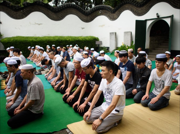 Chinese Muslims pray during the Eid al-Fitr prayer in the garden of the Songjiang Mosque in Shanghai on July on July 18, 2015. Muslims around the world are celebrating the Eid al-Fitr festival, which marks the end of the fasting month of Ramadan. AFP PHOTO / JOHANNES EISELE
