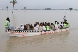 Rescuers of Falah-e-Insaniat Foundation (FIF), a charity organisation of banned Jamat ud Dawa, take part in relief and rescue operations in the Layyah District on July 25, 2015. Torrential rains and floods in Pakistan have left 36 dead and affected more than 250,000 people, disaster management officials said Saturday, with swollen rivers and water channels damaging hundreds of villages. AFP PHOTO / S S MIRZA