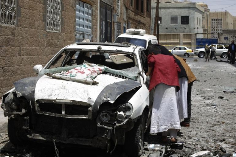 People look at the site of a car bomb attack in Sanaa, Yemen, Tuesday, June 30, 2015. The explosion occurred near a military hospital in the Yemeni capital on Monday, causing dozens of casualties including civilians, security officials said. The Islamic State's Sanaa Division claimed responsibility on Twitter for detonating the parked car bomb, according to the SITE Intelligence Group monitoring service. (AP Photo/Hani Mohammed)