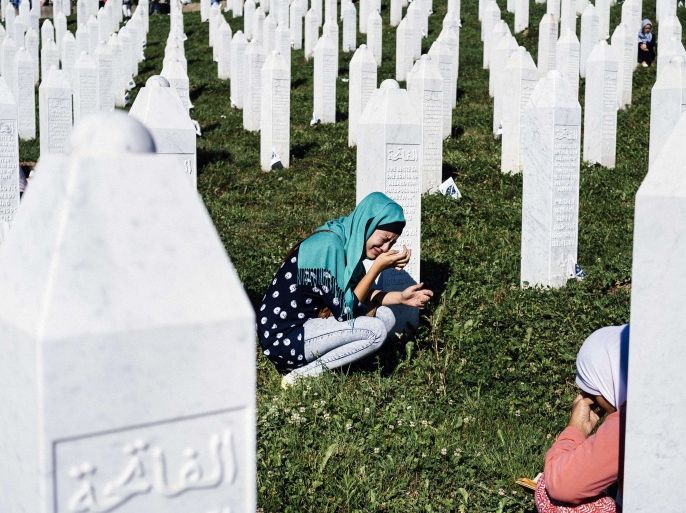Srebrenica, -, BOSNIA AND HERCEGOVINA : Bosnian women mourn at the grave of their relative on July 11, 2015 at the Potocari Memorial Center near the eastern Bosnian town of Srebrenica, where 136 bodies found in mass grave sites in eastern Bosnia will be reburied on 20th anniversary of the Srebrenica massacre. Thousands of people were pouring into Srebrenica today to commemorate the 20th anniversary of the massacre of thousands of Muslims in the worst mass killing in Europe since World War II. The remains of 136 newly-identified victims were to be laid to rest alongside more than 6,000 others already buried at a memorial centre just outside the eastern Bosnian town. AFP PHOTO / DIMITAR DILKOFF