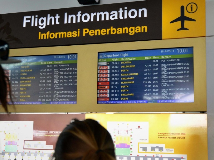Passengers look at the information board in the international terminal at Bali's Ngurah Rai airport in Denpasar hoping for information of flight delays due to volcanic ash near Indonesia's resort island on July 10, 2015. Ash drifting from an Indonesian volcano closed five airports on July 10, including the one on the holiday island of Bali, causing about 250 flights to be cancelled and stranding thousands of holidaymakers. The international airport on nearby popular Lombok island was also among those closed late on July 9 as Mount Raung in East Java province spewed clouds of ash. AFP PHOTO / SONNY TUMBELAKA