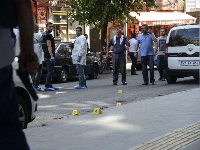 Turkish police officers check the area after an attack against Turkish police officers in the center of Diyarbakir on July 23, 2015. A Turkish police officer was shot dead and a second one wounded today in the mainly Kurdish city of Diyarbakir in the latest in a series of attacks that began with a suicide bombing blamed on ISIL, security sources said.AFP PHOTO/ILYAS AKENGIN