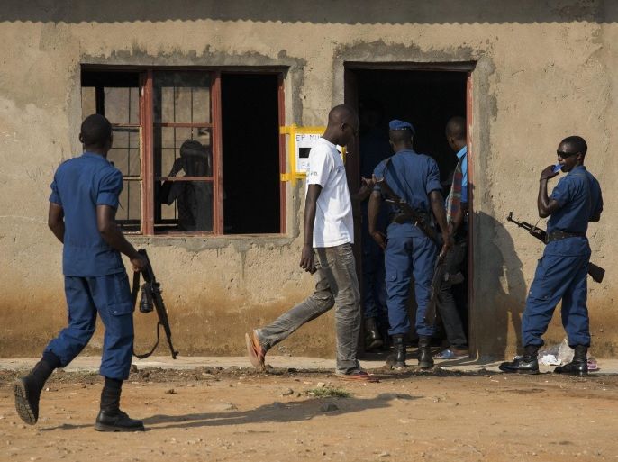 A Burundian voter walks into a polling station to cast his vote as police officers stand guard during the country's controversial Presidential election in the Cibitoke neighborhood of the capital Bujumbura, Burundi, 21 July 2015. Burundians were voting 21 July in a controversial presidential election, boycotted by the opposition and marred by violence. Witnesses reported gunfire and grenade explosions overnight. A police spokesman declined to immediately comment on reports that a police officer and a civilian had been killed in clashes.
