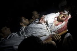 Mourners carry the body of Palestinian Mohammed Al-Masri, who was killed by Israeli gunfire in the northern Gaza Strip after he approached the border with Israel, during his funeral in Beit Lahia in the northern Gaza Strip on July 31, 2015