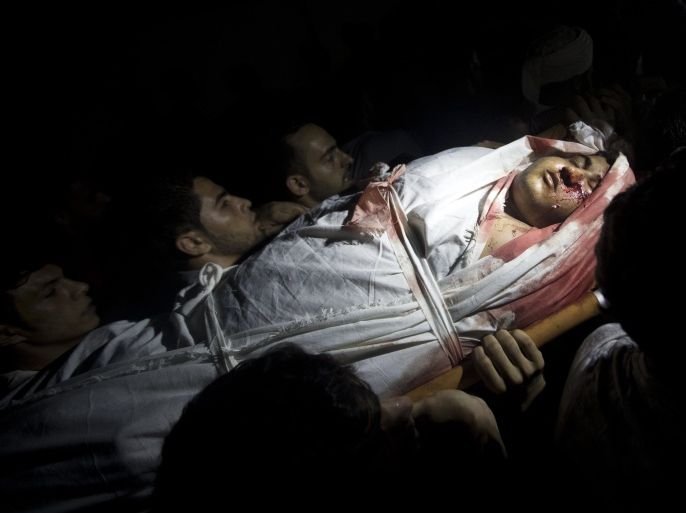 Mourners carry the body of Palestinian Mohammed Al-Masri, who was killed by Israeli gunfire in the northern Gaza Strip after he approached the border with Israel, during his funeral in Beit Lahia in the northern Gaza Strip on July 31, 2015