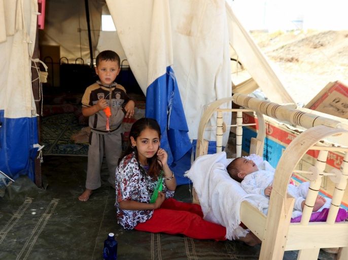 Children fleeing violence in the Iraqi city of Mosul, sit in front of a tent at a camp on the outskirts of Arbil June 13, 2015. REUTERS/Azad Lashkari