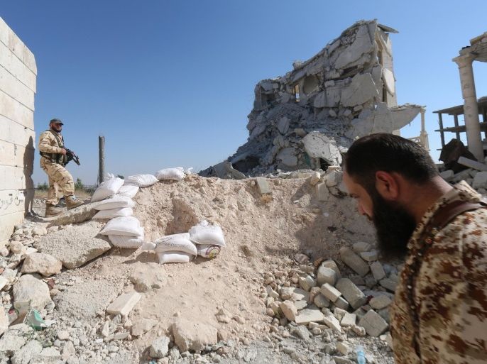 Rebel fighters walk on the rubble of destroyed buildings at a former research centre being used as a military barracks after they captured the complex, on July 4, 2015, on the western outskirts of the Syrian city of Aleppo. Two coalitions of Syrian rebels battled to advance in government-held western Aleppo, seizing the army barracks in one district but being pushed back in others. AFP PHOTO / ALEPPO MEDIA CENTRE / ZEIN AL-RIFAI