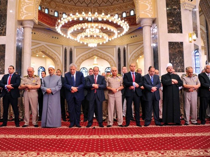 A handout picture provided by the Office of the Egyptian President shows the Egyptian President, Abdel Fattah al-Sisi (C), Egyptian Prime Minister, Ibrahim Mahlab (center - L) and the Grand Imam of al-Azhar, Ahmed El-Tayyeb (center 3 - L), observing morning prayers on the first full day of the Muslim holiday of Eid al-Fitr, which marks the end of the holy fasting month of Ramadan, at the Hussein Tantawi Mosque, Cairo, Egypt, 17 July 2015. Most Muslims around the world have begun celebrating the three day festival marking the end of the holy fasting month of Ramadan, known as Eid al-Fitr, set to start 17 or 18 July, and celebrated with prayers, readings from the Koran, and gatherings with family and friends. EPA/OFFICE OF THE EGYPTIAN PRESIDENT / HANDOUT