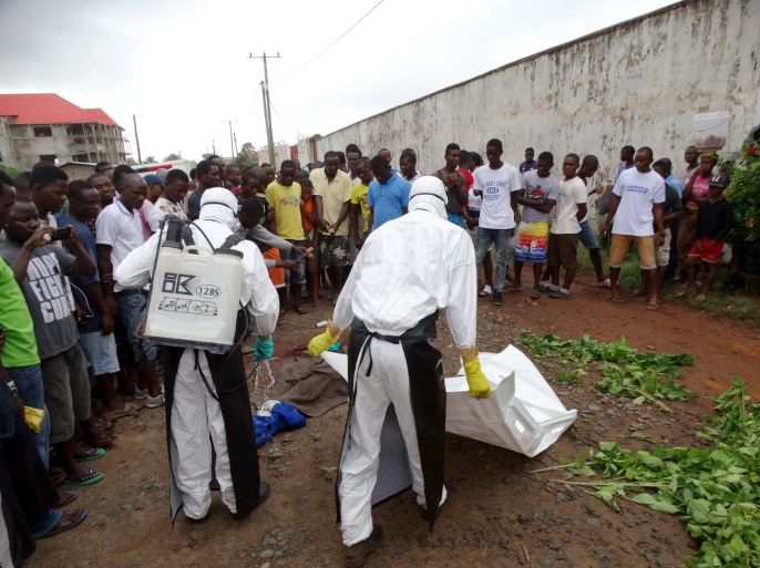 Healthcare workers prepare to remove the body of a man suspected of carrying Ebola in Monrovia, Liberia, July 17, 2015. REUTERS/James Giahyue