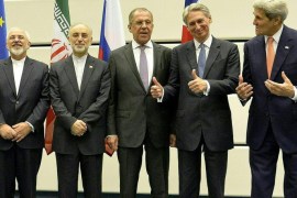 Both US Secretary of State John Kerry (extreme right) and British Foreign Secretary Philip Hammond (second from right) gesture towards Iranian Foreign Minister Mohammad Javad Zarif (extreme left) during a press conference following the conclusion of the E3+3 and Iran nuclear reduction talks, in Vienna 14 July 2015. Also in attendance is Iran's Ambassador to the IAEA Ali Akbar Salehi (second from left) and Russian Foreign Minister Sergei Lavrov (third from left)