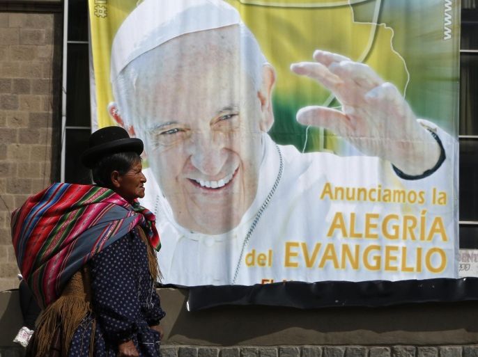 An Aymara indigenous woman walks past a billboard featuring Pope Francis with a message that reads in Spanish: "Announcing the joy of the Gospel" in La Paz, Bolivia, Friday, July 3, 2015. The pope's trip to South America that includes Bolivia is set for July 5-12, though he will only spend four hours in Bolivia's capital due to the altitude, church officials say. (AP Photo/Juan Karita)