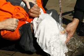 Demonstrator Maboud Ebrahimzadeh is held down during a simulation of waterboarding outside the Justice Department in Washington in this November 5, 2007 file photo. The possibility that U.S. spies located Osama bin Laden with help from detainees who'd been subjected to "enhanced interrogation" techniques seems certain to reopen the debate over practices that many have equated with torture, security experts said on Monday.