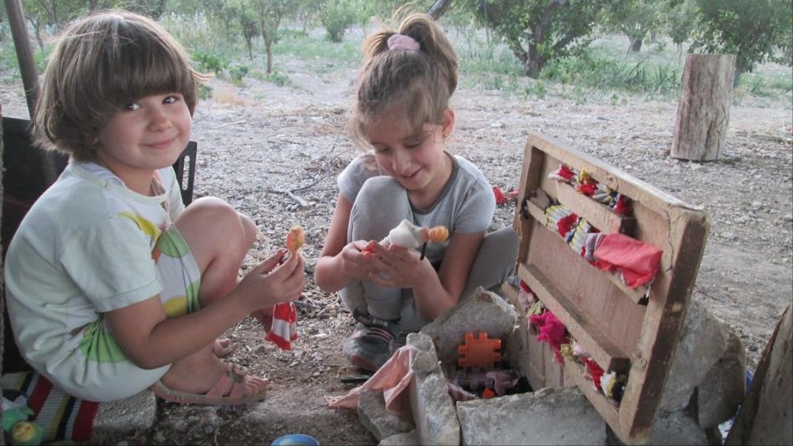 الطفلة هلا وشقيقتها يفتقدان العاب العيد المعروفة ويصنعان ألعابا خاصة بهما (الجزيرة)