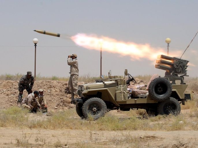 Members of Iraq's Shi'ite paramilitaries launch a rocket towards Islamic State militants in the outskirts of the city of Falluja, in the province of Anbar, Iraq July 12, 2015. REUTERS/Stringer