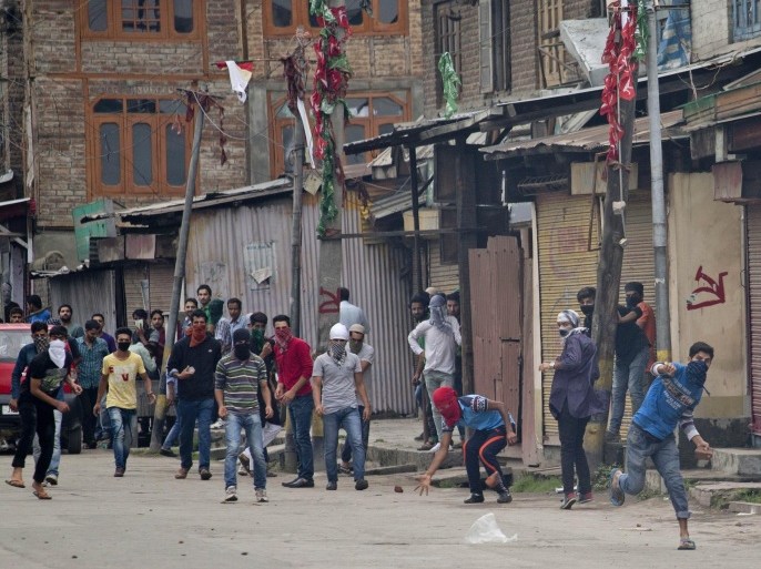 Masked Kashmiri Muslim protesters throw stones and bricks at Indian policemen during an annual protest marking the Al-Quds Day in Srinagar, Indian controlled Kashmir, Friday, July 17, 2015. Police in Indian controlled Kashmir fired tear gas shells to disperse hundreds of protesters who clashed with them during an annual protest marking Al-Quds Day. Al-Quds is the Arabic name for Jerusalem. (AP Photo/Dar Yasin)