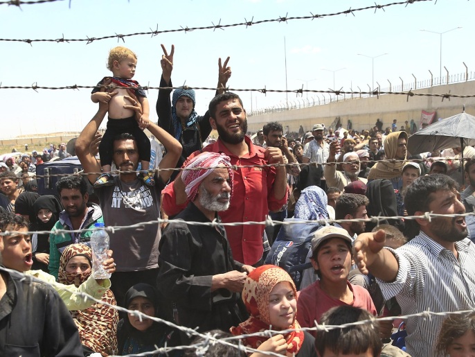لاجئون سوريون على الحدود التركية بعد فرارهم من مناطق القتال داخل بلادهم (أسوشيتد برس)