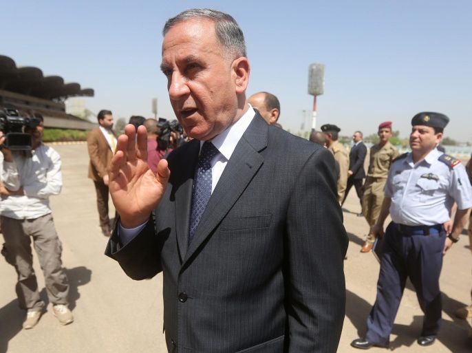 Iraqi Defense Minister Khaled al-Obeidi waves in Baghdad on April 29, 2015, during the funeral for the bodies of the victims believed to be massacred by jihadists after their remains were exhumed from mass graves in Tikrit. The mass grave sites were discovered after Iraqi forces retook the northern city of Tikrit earlier this month in their biggest victory so far against the Islamic State (IS) group. AFP PHOTO / AHMAD AL-RUBAYE