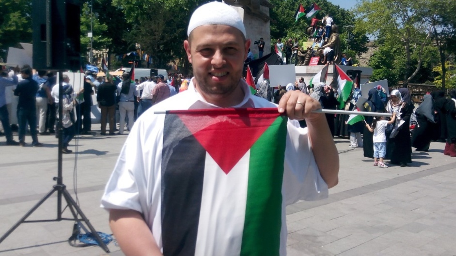 الجزائري المغترب في فرنسا علي بن علي يحمل علما فلسطينيا خلال المسيرة (الجزيرة نت)