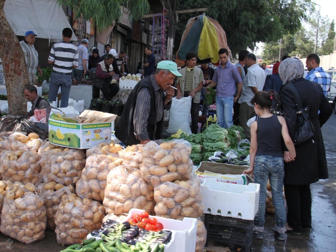 ‪سوريون يشترون الخضار من أحد الأسواق في العاصمة دمشق‬ (الأوروبية)
