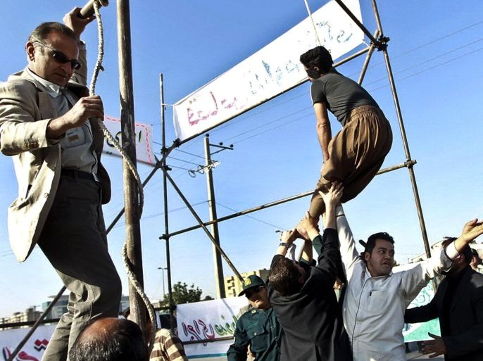 FILE - In this May 8, 2013, file photo released by the Iranian Mehr News Agency, men hold a man hanged in public, to prevent his execution, after he was pardoned by the family of the policeman he was convicted of killing, in Mashhad, northeastern Iran. Under Sharia law, a victim's family has the option to forgive the criminal rather than allowing the perpetrator to be executed. According to a report by Amnesty International released on Wednesday, April 1, 2015, Iran had at least 289 recorded executions in 2014. (AP Photo/Mehdi Bolourian)