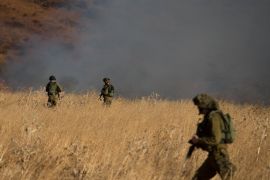 Israeli soldiers patrol next to a smoke from a fire caused by a rocket attack in northern Israel, near the Lebanese border, August 20, 2015. Rockets that struck a northern Israeli village near the Lebanese border on Thursday, causing no casualties, were launched from the Syrian Golan Heights, the Israeli army said. REUTERS/JINIPIX ISRAEL OUT