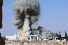 FILE - This undated file photo released Tuesday, Aug. 25, 2015 on a social media site used by Islamic State militants, which has been verified and is consistent with other AP reporting, shows smoke from the detonation of the 2,000-year-old temple of Baalshamin in Syria's ancient caravan city of Palmyra. The nearly 2,000-year-old temple in the Syrian city of Palmyra this week was the latest victim in the Islamic State group’s campaign of destruction of historic sites across the territory it controls in Iraq and Syria. Arabic at bottom reads, "The moment of detonation of the pagan Baalshamin temple in the city of Palmyra." (Islamic State social media account via AP, File)
