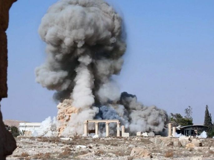 FILE - This undated file photo released Tuesday, Aug. 25, 2015 on a social media site used by Islamic State militants, which has been verified and is consistent with other AP reporting, shows smoke from the detonation of the 2,000-year-old temple of Baalshamin in Syria's ancient caravan city of Palmyra. The nearly 2,000-year-old temple in the Syrian city of Palmyra this week was the latest victim in the Islamic State group’s campaign of destruction of historic sites across the territory it controls in Iraq and Syria. Arabic at bottom reads, "The moment of detonation of the pagan Baalshamin temple in the city of Palmyra." (Islamic State social media account via AP, File)