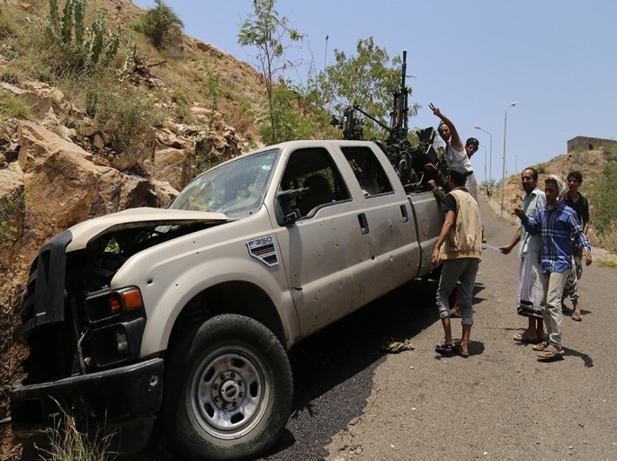 AB07 - TAEZ, -, YEMEN : Fighters loyal to Yemen's exiled President Abedrabbo Mansour Hadi stand next to a pick-up truck mounted with a heavy machine gun after they seized it from Shiite Huthi rebels in the country's third city Taez on August 20, 2015. Clashes in the city have intensified in recent days after pro-government forces made sweeping territorial gains against the Iran-backed rebels. AFP PHOTO / AHMAD AL-BASHA