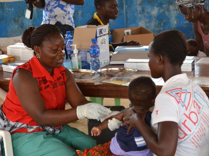 A child is vaccinated against measles in a poor neighborhood of Monrovia on March 19, 2015. The people of Monrovia's Peace Island ghetto, refugees of civil war who found themselves suddenly overwhelmed and outmanoeuvred by the deadly Ebola epidemic, are used to life under siege. Yet with Liberia emerging from the worst outbreak in history a year to the day since Ebola was first identified in west Africa, the slum-dwellers are facing an even deadlier threat -- the measles virus. AFP PHOTO / ZOOM DOSSO