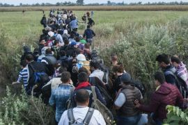 Illegal migrants make their way near the railway crossing at the border between Hungary and Serbia near Roszke, 180 kms southeast from Budapest, Hungary, Tuesday Aug. 25, 2015. (Sandor Ujvari/MTI via AP)