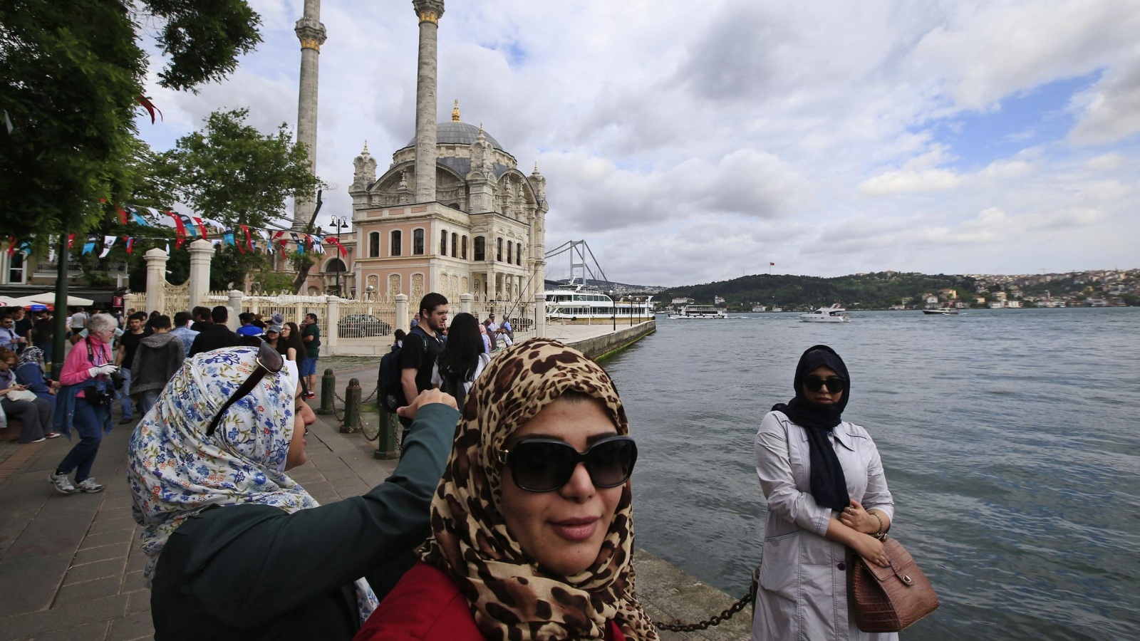 ‪سياح يلتقطون صورا على ضفة البوسفور بمدينة إسطنبول‬ (أسوشيتد برس)