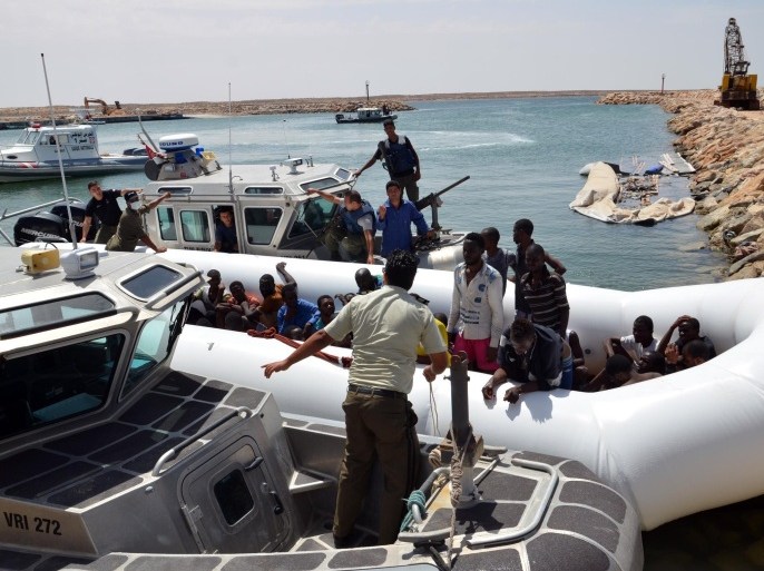 Migrants arrive at the El-Kitif port in the Tunisian town of Ben Guerdane, some 40 kilometres west of the Libyan border, following their rescue by Tunisia's coastguard and navy after their vessel overturned off Libya, on August 23, 2015. 125 migrants, including 28 women, were rescued from two boats which broke down as they headed from Libya to Italy, an AFP photographer said. AFP PHOTO / FETHI NASRI