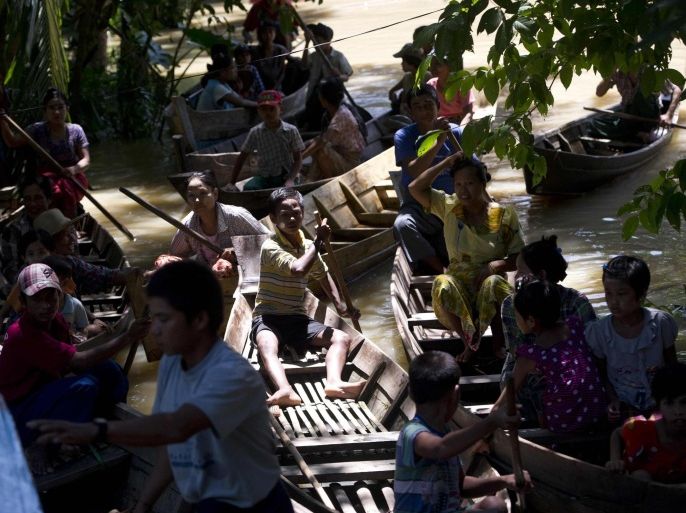 Flood-affected residents wait for supplies in Kyouk Taing village near Nyaung Don township in Myanmar's Irrawaddy region on August 7, 2015. Twelve of Myanmar's 14 regions have been struck, with officials saying 74 people have been killed and more than 330,000 affected -- many forced into monasteries and other makeshift shelters after their homes were inundated. AFP PHOTO / Ye Aung THU