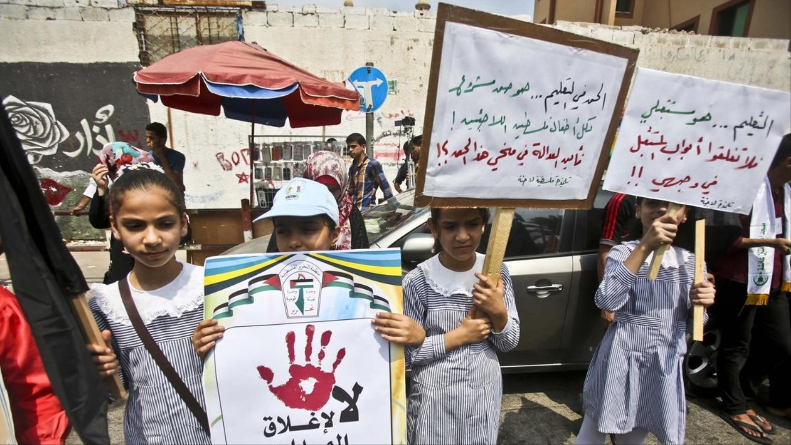 أطفال يحملون لافتات ضد إغلاق مدارس الأونروا (الأناضول)