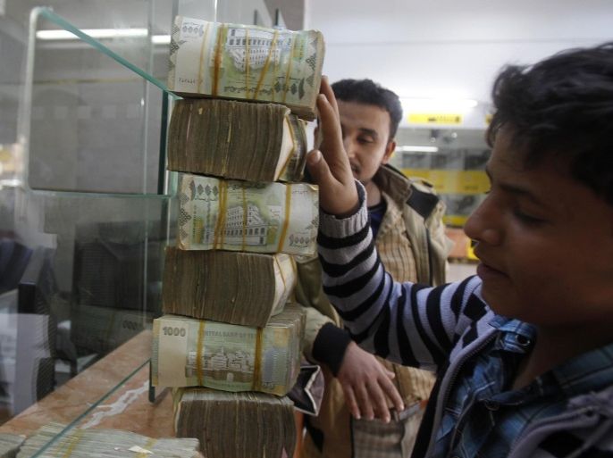 A customer receives bundles of Yemeni Riyal banknotes at an exchange company in Sanaa February 10, 2013. Yemen's fledgling economic recovery is good news for efforts to restore political stability in the country, which is important for the entire region because it lies near major oil shipment routes. The recovery is also a positive omen for other Arab Spring states which are struggling to rebuild their economies after political turmoil in the past two years. Picture taken February 10, 2013. REUTERS/Khaled Abdullah (YEMEN - Tags: BUSINESS POLITICS)