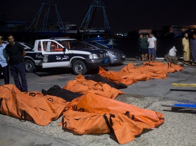 In this Thursday, Aug. 27, 2015 photo, bodies of migrants who drowned off the coast when their boat sank are collected in Zuwara, Libya. It was not clear how many migrants had drowned. Dozens of boats are launched from lawless Libya each week, with Italy and Greece bearing the brunt of the surge. (AP Photo/Mohamed Ben Khalifa)