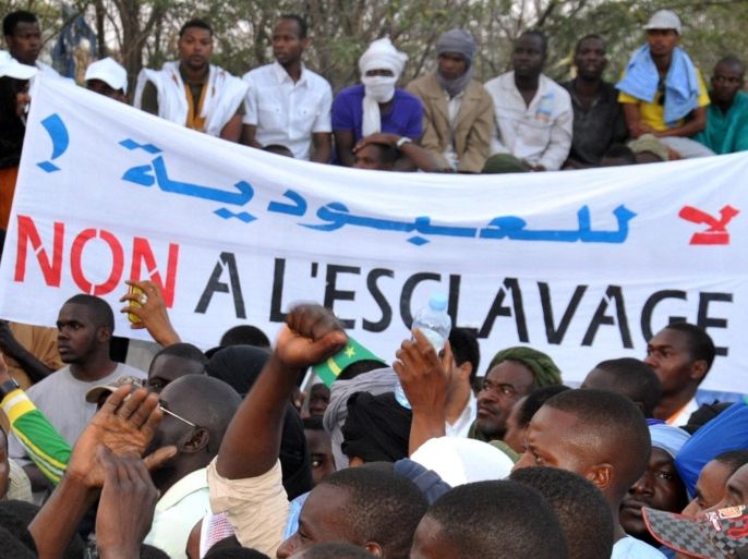 People hold a banner reading 'No to slavery' during a demonstration against discrimination in Nouakchott on April 29, 2015. Thousands of descendants of Moorish slaves in Mauritania, known as the 'Haratin', protested in Nouakchott on the evening of April 29 against discrimination and to demand justice and equality for the Haratin. AFP PHOTO / STRINGER