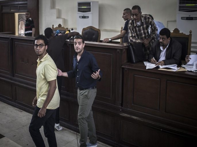 Egyptian Al-Jazeera journalist Baher Mohamed (l) and co-defendant Shadi Ibrahim gesture after a verdict in the Al-Jazeera trial was postponed in the court room of Tora prison in Cairo, Egypt, 02 August 2015. After the verdict was postponed for a second time within days, court officials announced the verdict in the retrial will be given on August 29th.