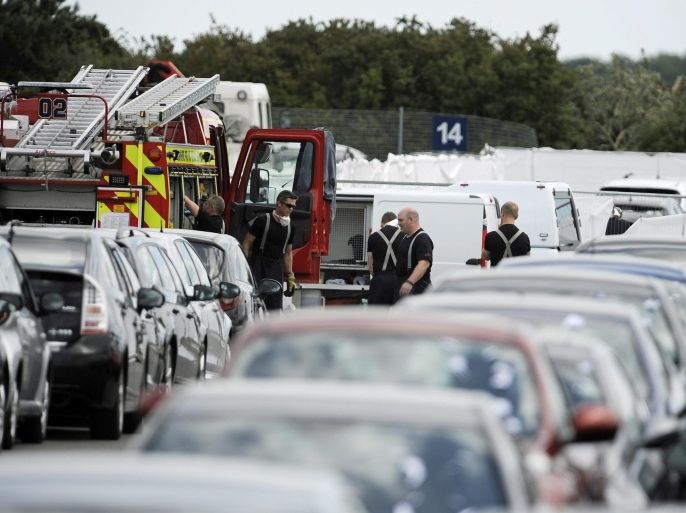 Hampshire police and firefighters at the scene of the Embraer Phenom 300 jet crash site at the British Car Auctions, Blackbushe, Hampshire, southern England, 01 August 2015. Relatives of the late al-Qaeda leader Osama bin Laden were killed when a private plane crashed as it approached the runway at Blackbushe Airport, the Saudi embassy said in statement on 31 July 2015.