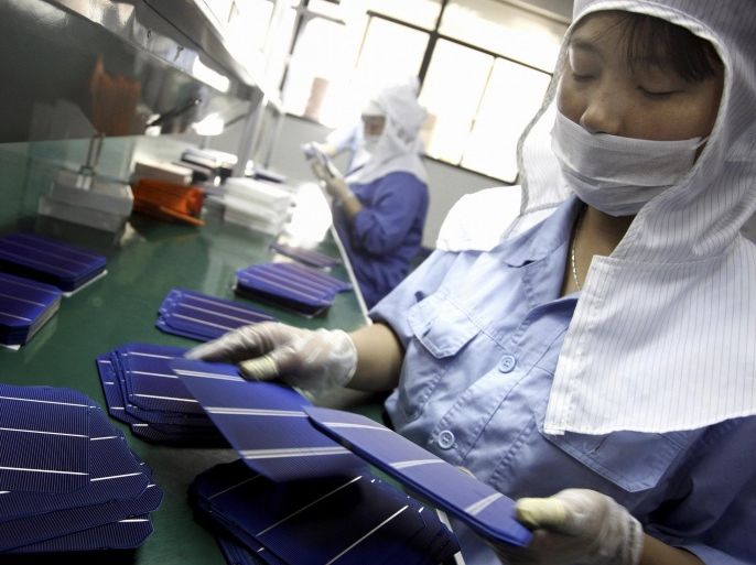 In this photo taken Monday May 13, 2013, a worker monitors a solar panel production line in a factory in Quzhou city in east China's Zhejiang province. China's government on Wednesday, June 5, 2013 criticized European anti-dumping tariffs imposed on Chinese solar panels and announced its own investigation of European wine exports. (AP Photo) CHINA OUT.