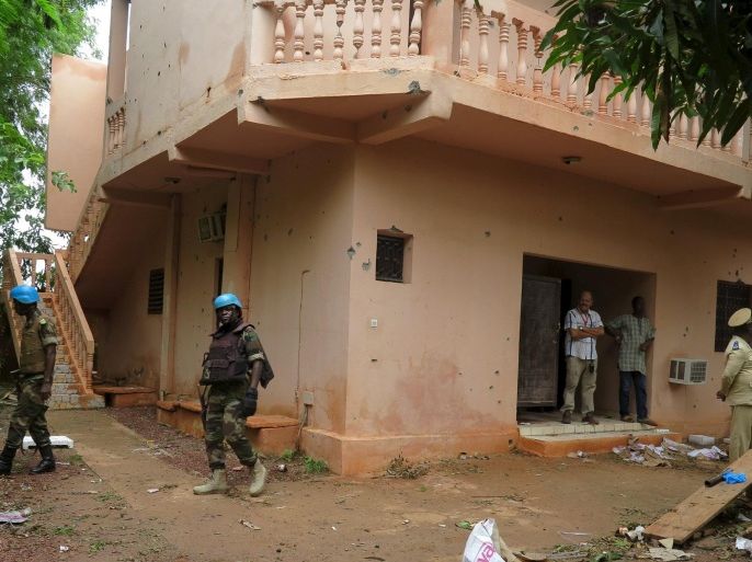 Malian soldiers survey the damage after a hotel siege over the weekend in which 17 people died in Sevare, Mali, August 11, 2015. Sahara-based Islamist militant group al-Mourabitoun has claimed responsibility for the siege in central Mali, Qatari-based television network Al Jazeera reported on Monday. There was no independent confirmation from the group, which is linked to al Qaeda and has been behind several attacks against Western interests in the Sahel region. REUTERS/Adama Diarra