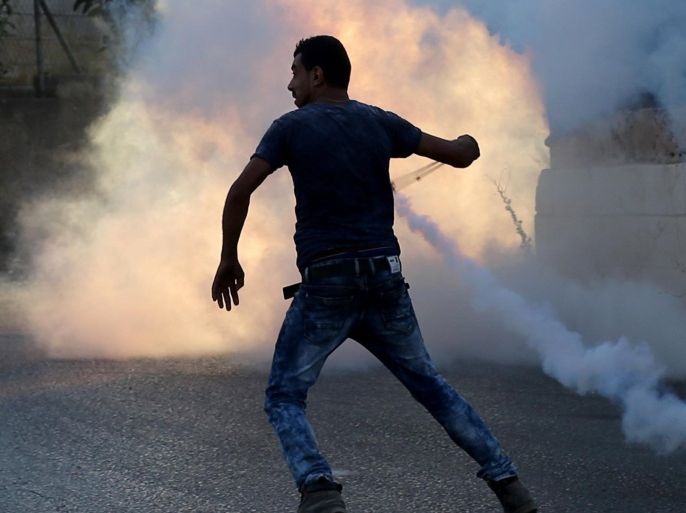 A Palestinian protester uses a slingshot during clashes with Israeli security forces on July 31, 2015 nearby the Jalazoun Palestinian refugee camp and the Jewish settlement of Beit El, north of Ramallah in the occupied West Bank, after a demonstration in reaction to the death of a Palestinian toddler who was burned in an arson attack by suspected Jewish settlers on two homes in the West Bank. AFP PHOTO / ABBAS MOMANI