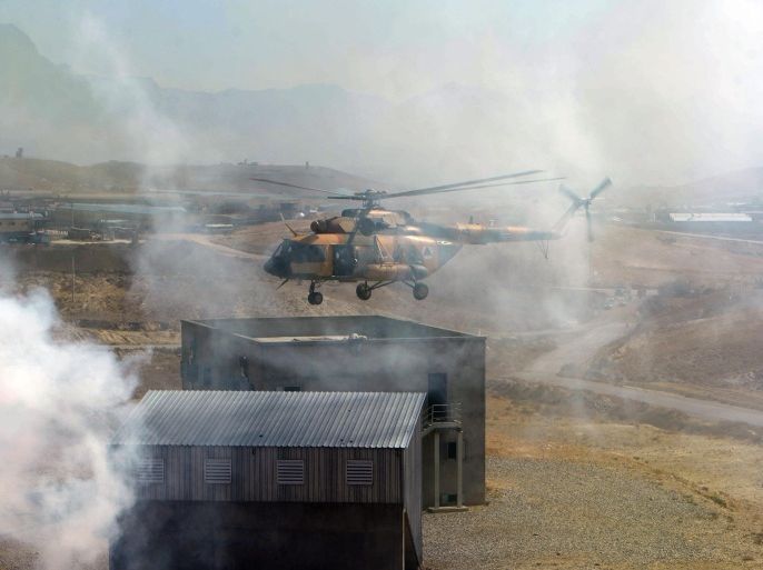 An Afghan Air Force Mi-17 helicopter hovers as Afghan National Army (ANA) soldiers participate in a combat training exercise at the Afghan National Military training centre (KMTC) in Kabul on October 22, 2014. Afghan casualties have rocketed over the past two years, during which time NATO has handed over most combat duties to the nation's police and army. The US military estimated this month that 7,000-9,000 Afghan police or troops had been killed or wounded so far this year. AFP PHOTO/Wakil Kohsar
