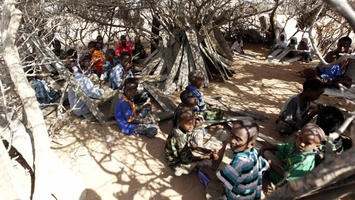 Refugee pupils use pieces of wood with Quranic verses written on them at a makeshift madrasa, or Islamic school, under a tree at the IFO 2 east camp within the Dadaab refugee complex, near the Kenya-Somalia border, October 29, 2014. REUTERS/Thomas Mukoya (KENYA - Tags: EDUCATION RELIGION SOCIETY)