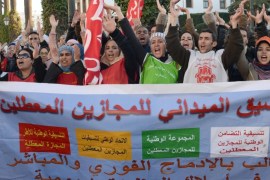 Protesters shout slogansbehind a banner during a rally on February 20, 2014 in Rabat to demand change on the anniversary of Morocco's pro-reform movement. Members of the February 20 movement were joined in Rabat by unemployed school leavers and Berber activists as they waved banners and chanted slogans denouncing corruption, injustice and despotism outside parliament, an AFP journalist reported. AFP PHOTO / FADEL SENNA