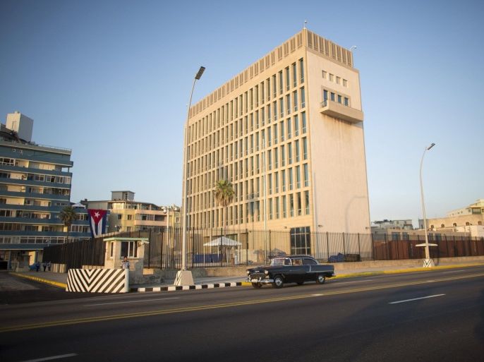 A vintage car passes by as a security officer stands on the corner of the U.S. embassy in Havana August 12, 2015. U.S. Secretary of State John Kerry will walk inside its iron fence on Friday and raise a U.S. flag to mark the restoration of diplomatic ties after five decades of Cold War hostility. Picture taken August 12, 2015. REUTERS/Alexandre Meneghini