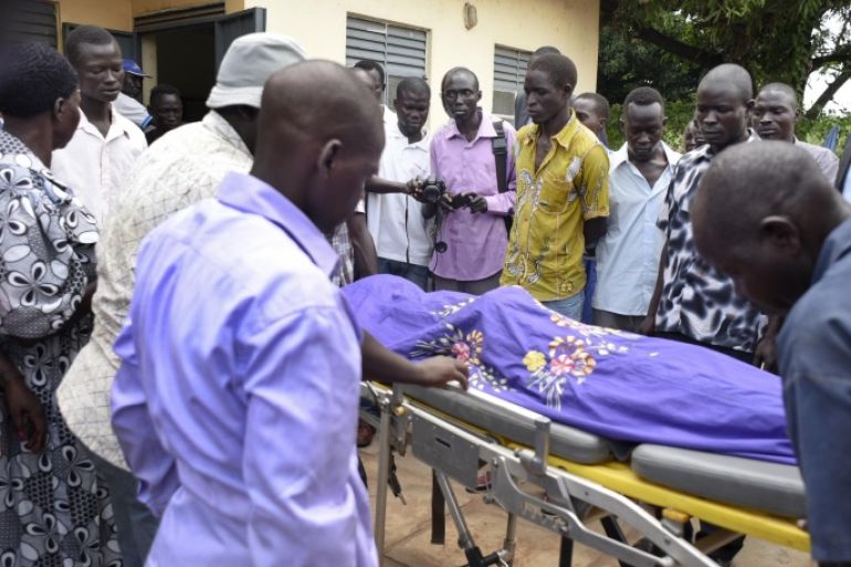 Relatives and other mourners watch as the body of South Sudanese journalist Peter Julius Moi is taken into the mortuary in Juba, South Sudan Thursday, Aug. 20, 2015. The father of Moi, a reporter for the Corporate Weekly, says unknown gunmen shot his son twice in the back and killed him late Wednesday, Aug. 19, 2015 on the outskirts of the capital Juba, in an attack that came days after President Salva Kiir was reported to have threatened to kill reporters "working against the country." (AP Photo/Jason Patinkin)